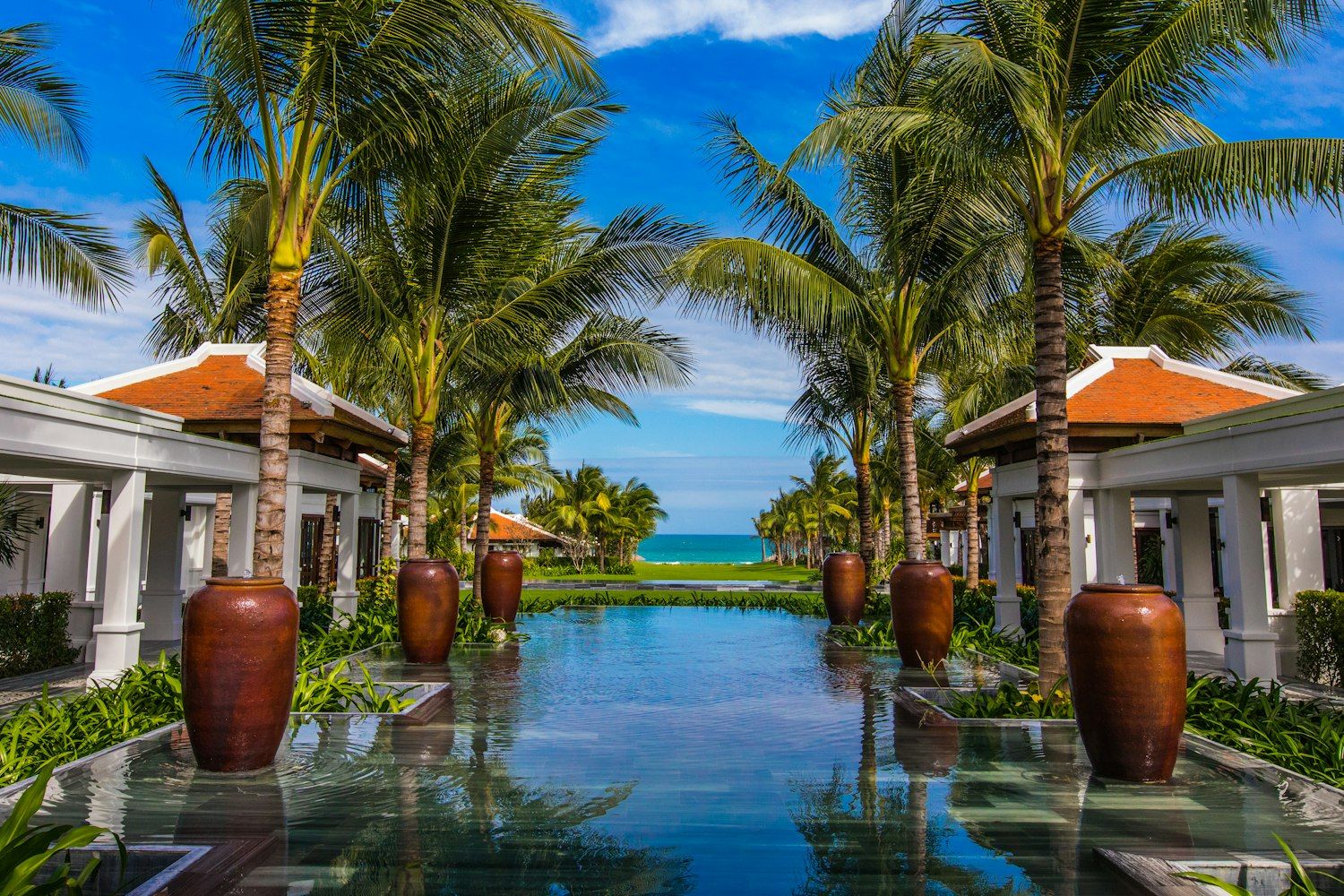 Palm-lined resort courtyard opening onto the sea